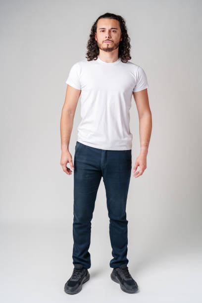istock A young man with curly hair stands confidently against a neutral background 2183217006