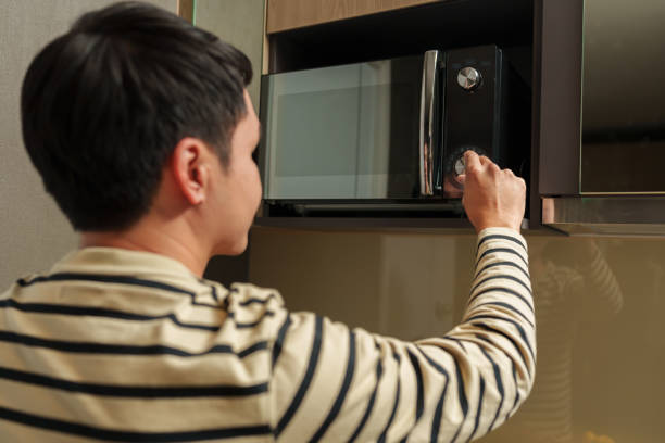 istock man cooking with a microwave in kitchen room 2183217285