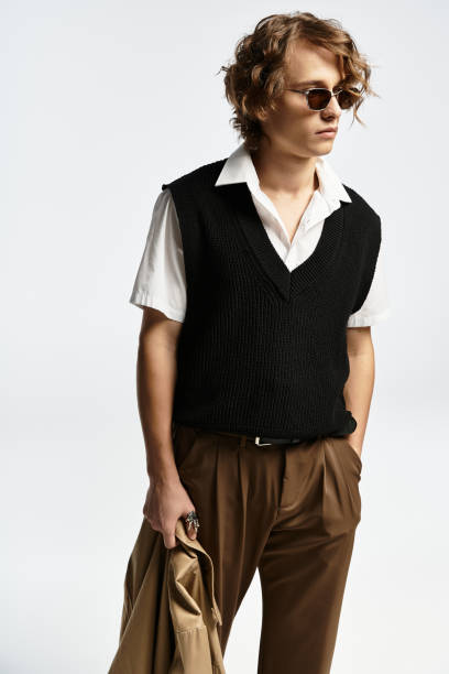 istock Stylish young man in a chic autumn outfit posing elegantly in a studio atmosphere 2183217874