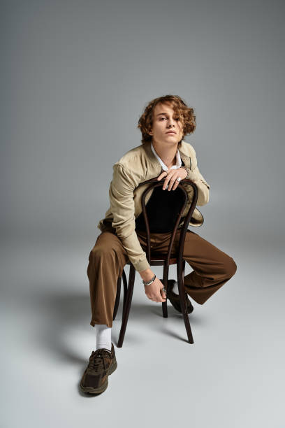 istock Stylishly dressed young man poses confidently in a chic autumn studio setting 2183218982