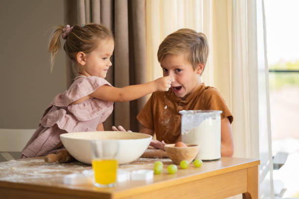 istock Happy siblings making cookies at home 2183219327