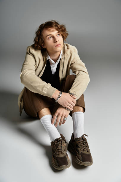 istock Charming young man in a stylish autumn outfit poses in a modern studio 2183219564