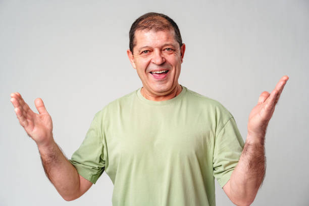 istock Cheerful man in a green shirt expressing happiness with open hands against a plain background 2183219866