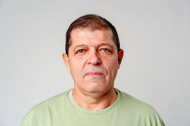 istock A mature man stands against a plain background, showcasing a calm expression 2183219941