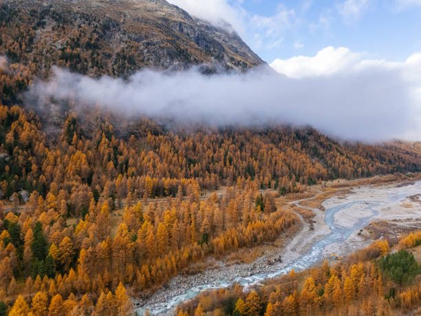 istock Autumnal Mountain Valley with River and Misty Clouds 2183220165