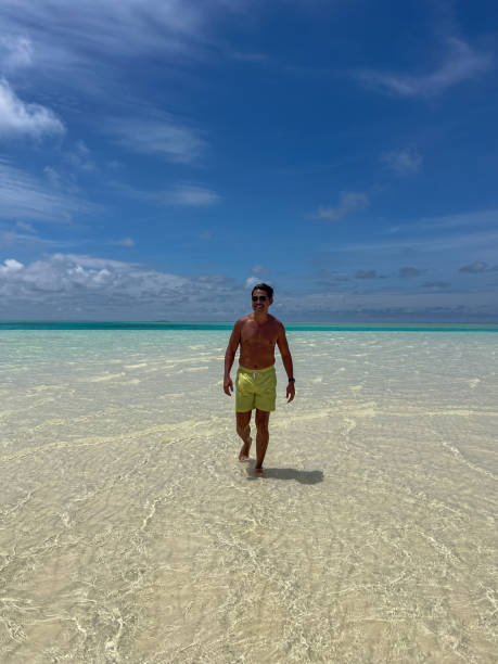 istock Man Walking on a Tropical Sandbar in Clear Waters 2183220838