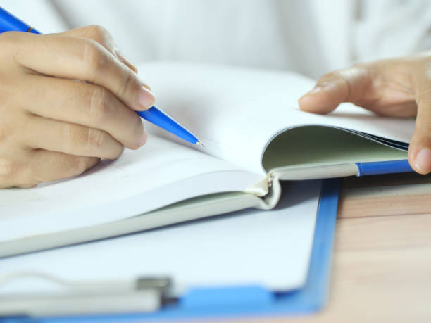 istock Hand holding pen writing on note paper. Finance business concept. Copy space. 2183221871