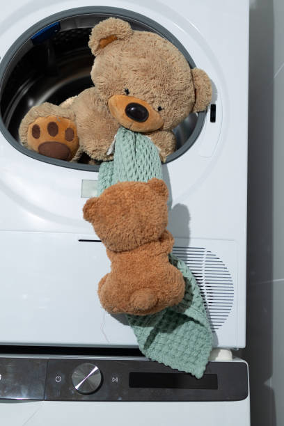 Adorable and delightful Teddy Bears amusingly playing around and inside a Washing Machine