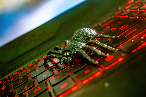 istock A black toy spider with glowing green eyes is placed on a backlit red keyboard, creating a striking contrast. Ideal for Halloween or tech related themes 2183226213