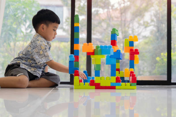 istock Asian little boy with toy building blocks testing his creativity by building towers learning 2183226226