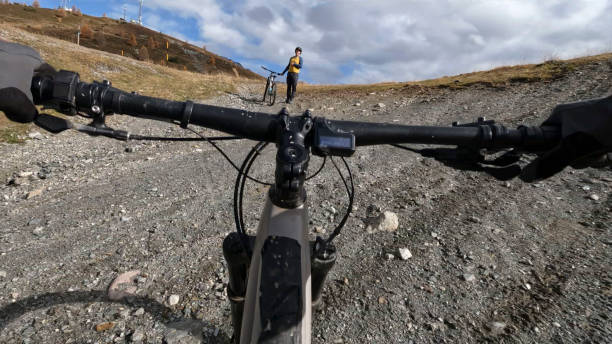 istock POV to mountain biker following friends down mountain trail 2183226608