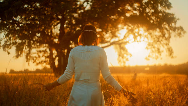 istock Serene Sunset Stroll by Mature Woman in Meadow 2183231003