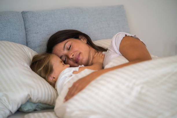 istock Mother and daughter sleep together in bed 2183232411