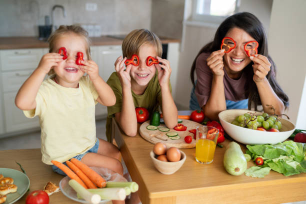istock A mother and children with pepper slices having fun while preparing dinner 2183234087
