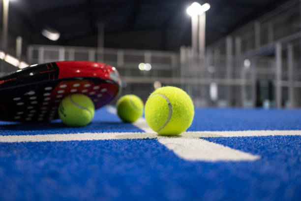 Paddle tennis racket and balls on blue turf