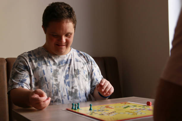 istock Young man with Down syndrome playing a board game 2183240153