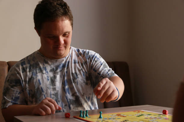 istock Young man with Down syndrome playing a board game 2183240194