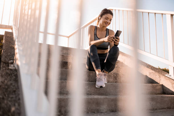 istock Athletic woman using phone outdoors. 2183243458