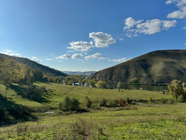 istock A Serene and Beautiful Landscape Featuring Rolling Hills and a River Beneath a Clear Blue Sky 2183244002