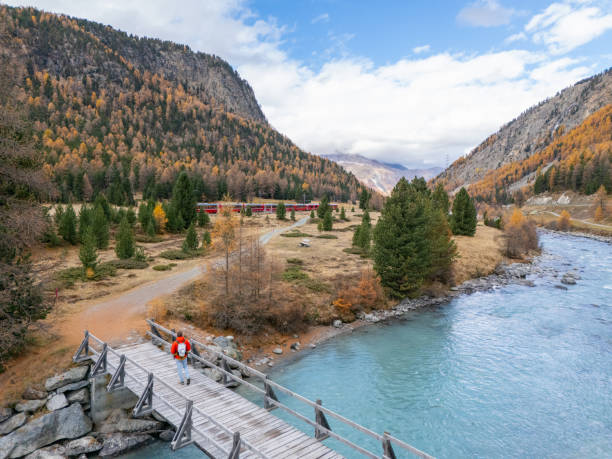 istock Person on Bridge Over River in Scenic Mountain Valley 2183244348