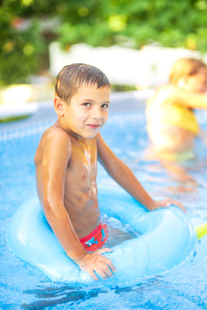 istock Boy relaxing on inflatable ring in swimming pool 2183245018