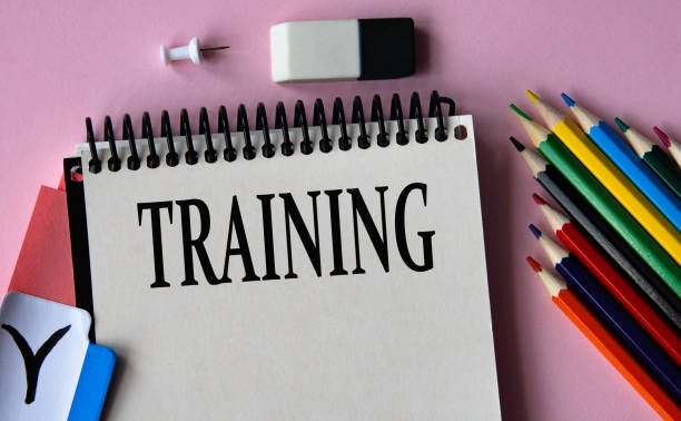 istock TRAINING - a word written in a notebook on a pink background and colored pencils 2183245589