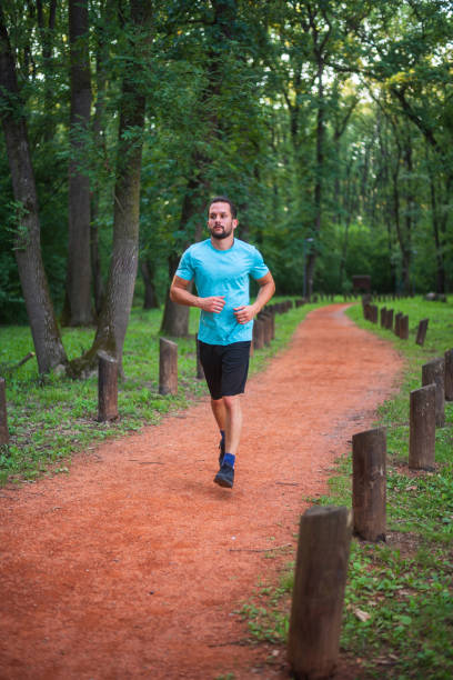 istock Young man running on a trail in the forest 2183246541