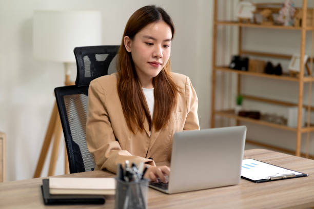 istock Young business woman using computer at desk in marketing 2183247026