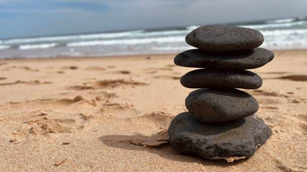 istock Stacked stones on a beach with ocean waves. 2183247223