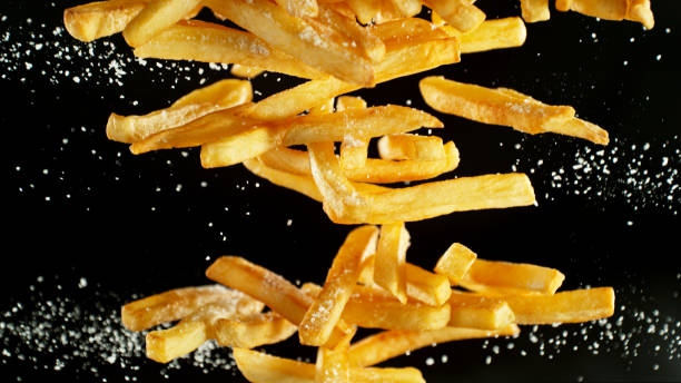 istock French fries - fried potatoes flying. 2183249993