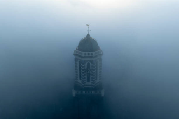 The Peperbus tower of the The Roman Catholic Onze Lieve Vrouwe ten Hemelopneming-basilica church in Zwolle rising up above the fog. The church tower, called Peperbus (pepperpot), is one of the tallest and most famous church towers in the Netherlands.