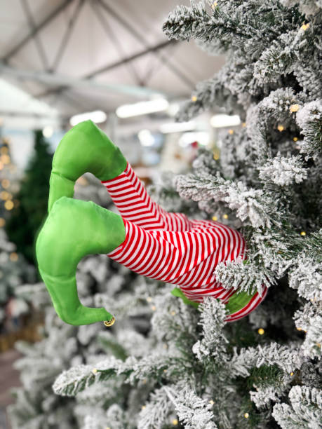 istock Image of whimsical christmas tree with elf legs, father xmas ornaments, artificial branches and needles, fake snow 2183250759