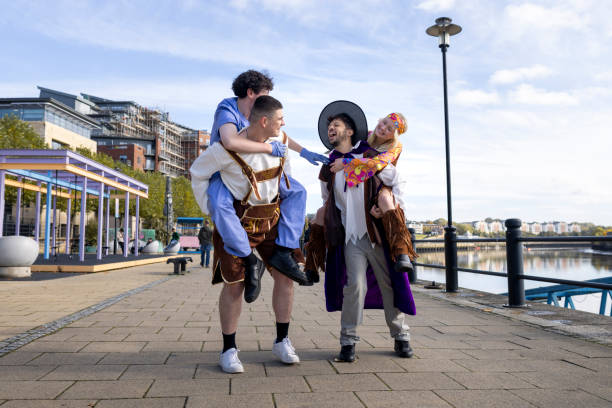 A group of friends in playful costumes share laughs and piggyback rides along Newcastle's riverside, heading to a fancy dress party. The mix of characters and bright autumn backdrop adds a lively, festive vibe to the scene.\n\nVideos are available similar to this scenario.