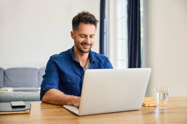 Happy man working on laptop at home