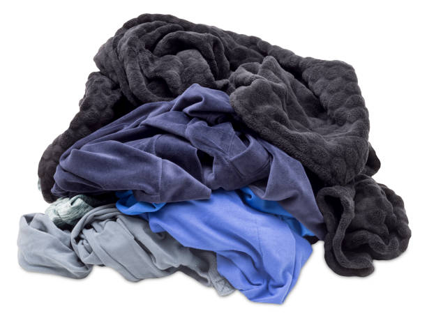 Crumpled pile of various clothes isolated on white background. Front view. Ideal for themes related to fashion, laundry, recycling. Cut out heap of clothing.