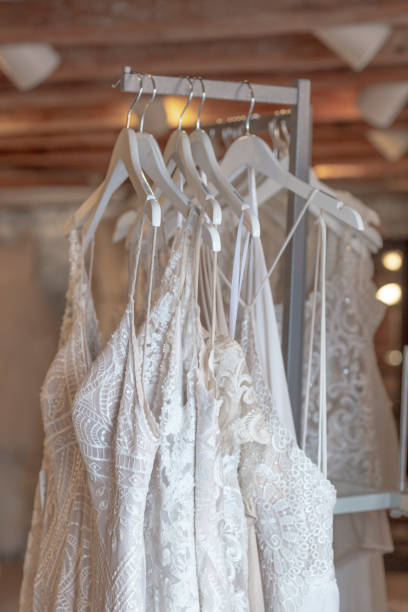 istock Delicate lace wedding dresses hang elegantly on a rack 2183253548