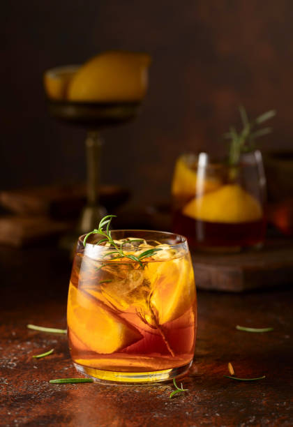 istock Iced tea or cocktail with ice, rosemary and lemon slices on the old brown table. 2183253991
