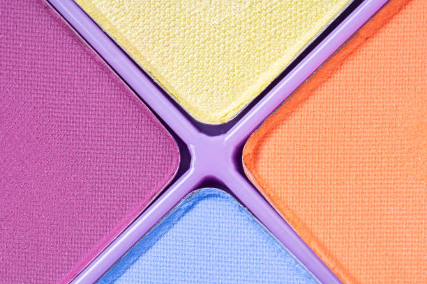 Close up of colorful eye shadow samples, trend color . Eyeshadows shiny and matte, top view palette in blue, yellow, pink and orange colors.