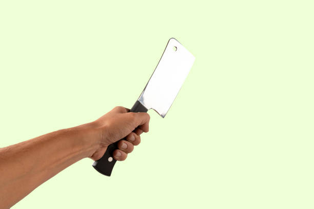 Hand holding a butcher knife isolated on green background. High quality photo