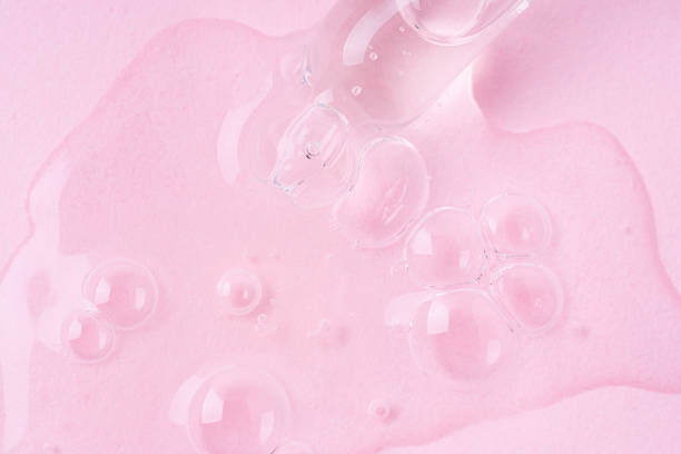 istock Macro shot of serum flows from pipette on pink background. 2183257699