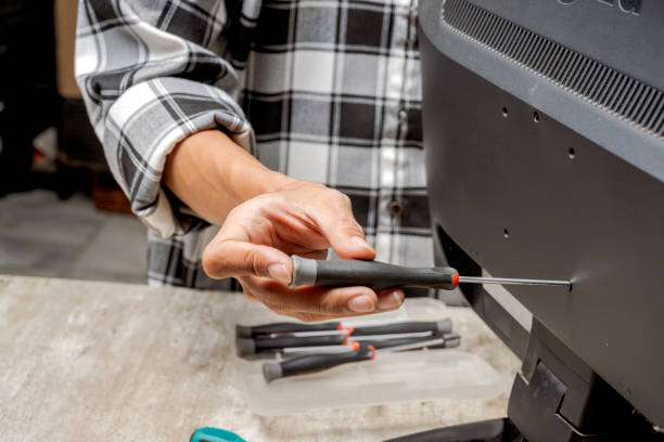 istock Man technician repairing television with a screwdriver 2183259032