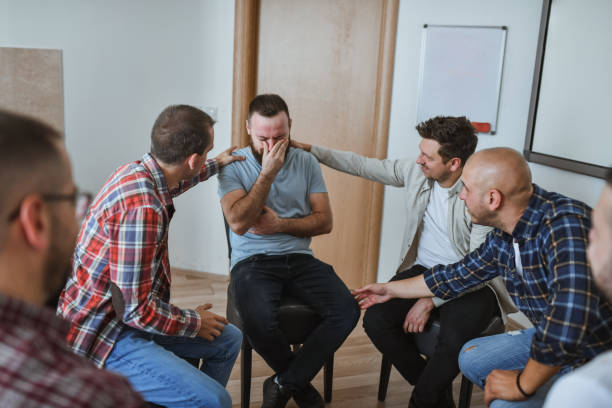 istock Emotional Men Crying in Group Therapy While Friends Are Giving Him Emotional Support 2183263061