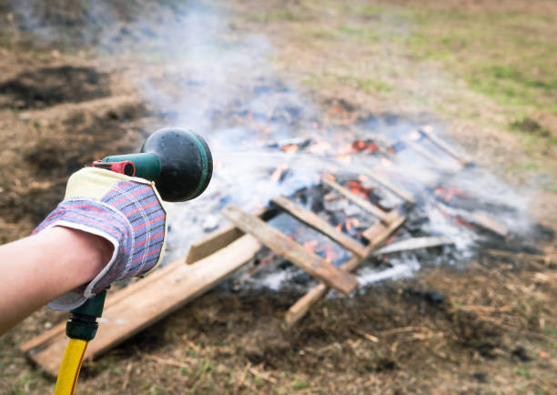 istock Gardener Extinguishing Small Fire with Hose in Backyard Setting 2183266023