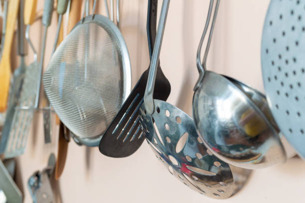 A wall of kitchen utensils including a spatula, a ladle, and a colander