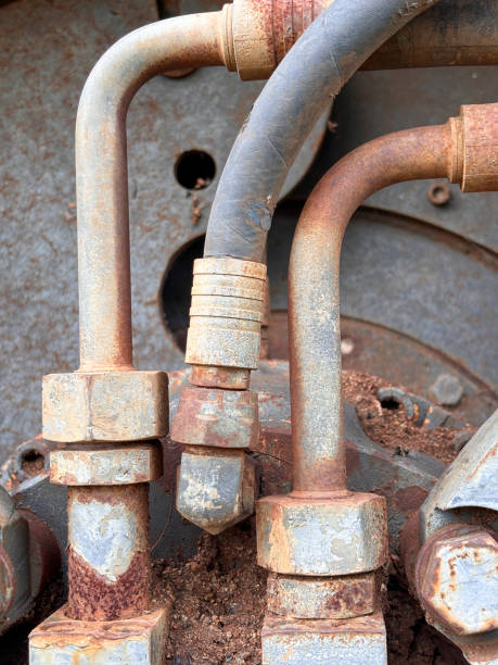 istock A rusty pipe with three different colored pipes coming out of it 2183273706