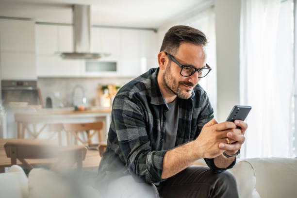 istock Positive man interacting with his smartphone, bringing a touch of joy to his home routine 2183275079