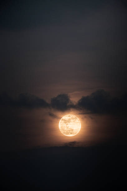 istock A golden full moon shrouded in clouds 2183276201