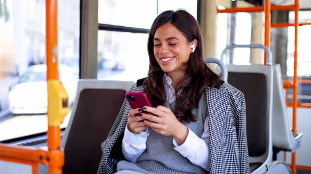 istock Young woman texting on her phone while traveling on a city bus 2183276202