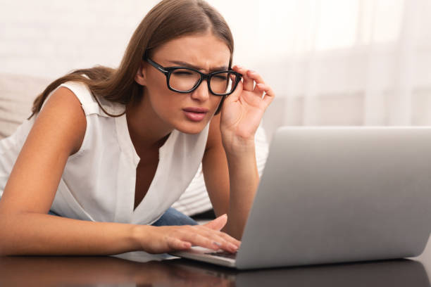 istock Woman Looking Through Eyeglasses At Laptop Sitting On Couch Indoor 2183283687