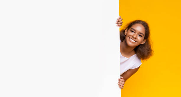 istock Joyful afro girl looking from big white board for advertising 2183283843